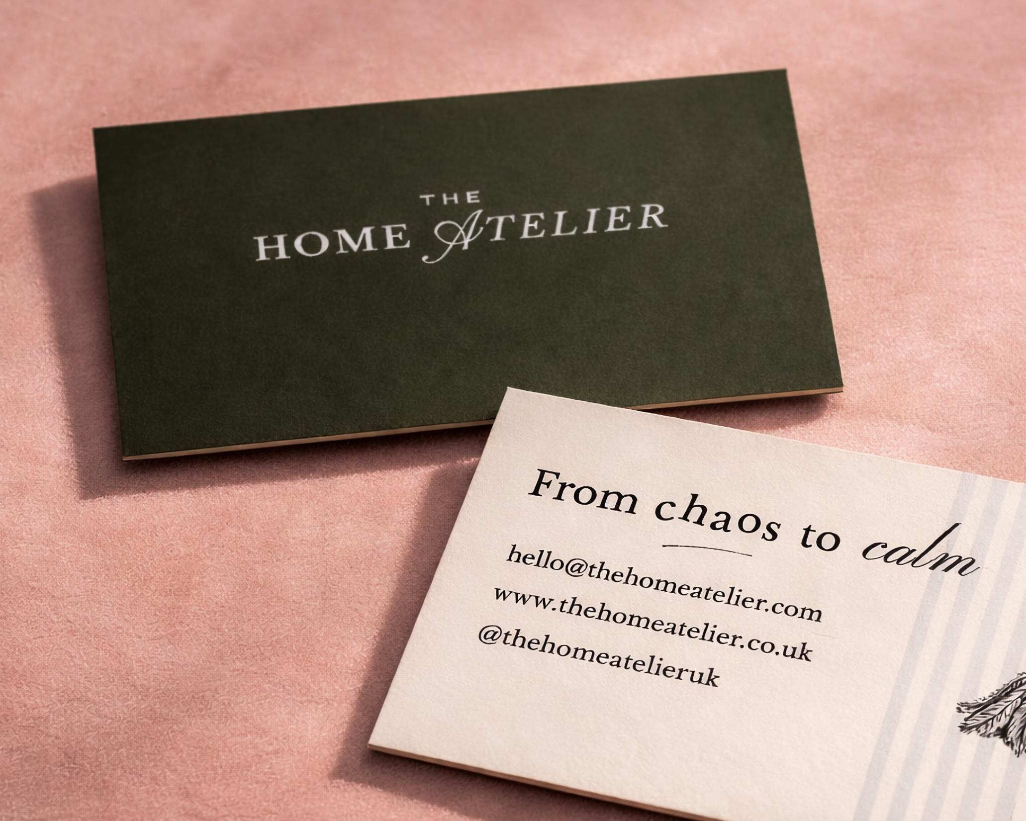 Business cards from The Home Atelier on a pink background